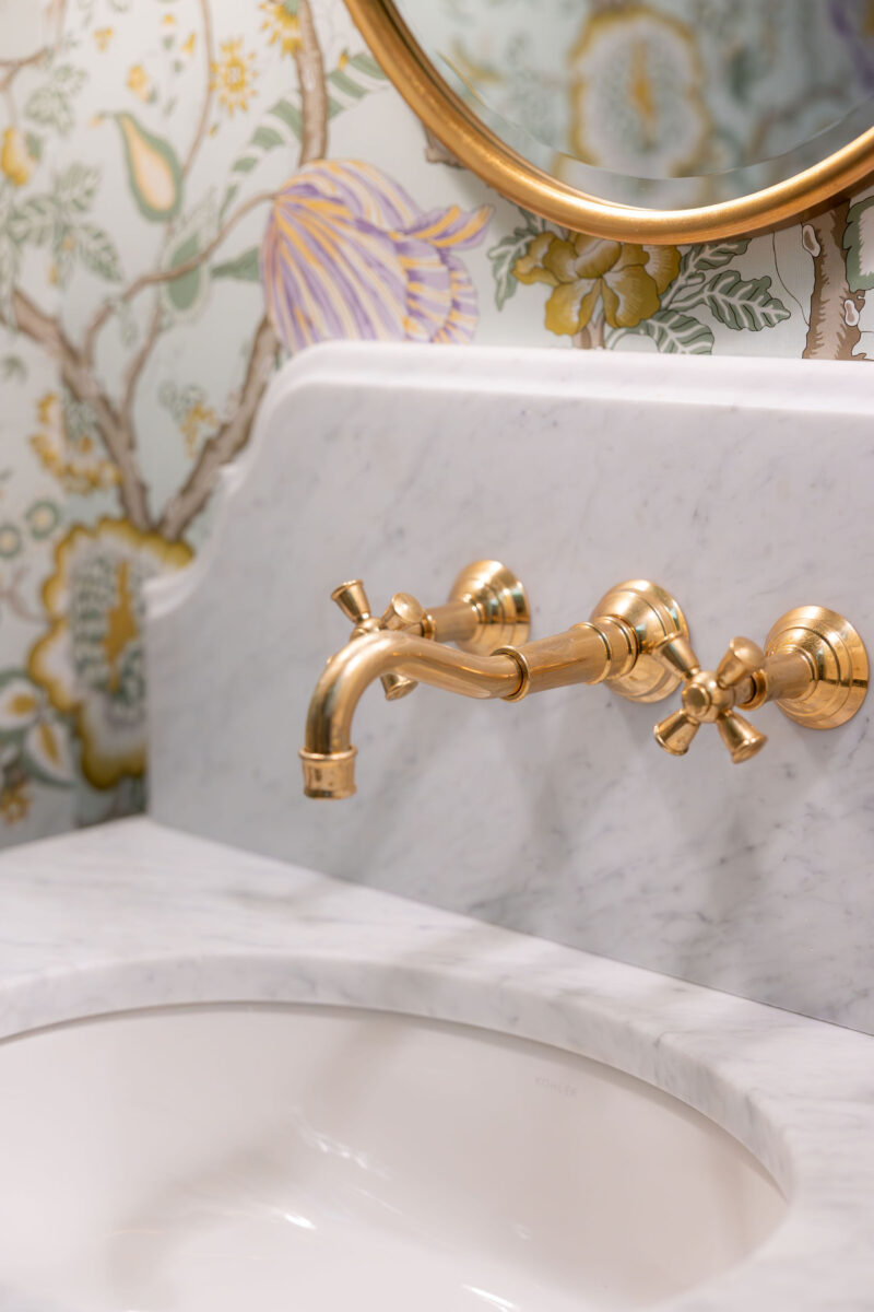 Polished brass wall mount faucet in a powder bathroom | Twin Construction 