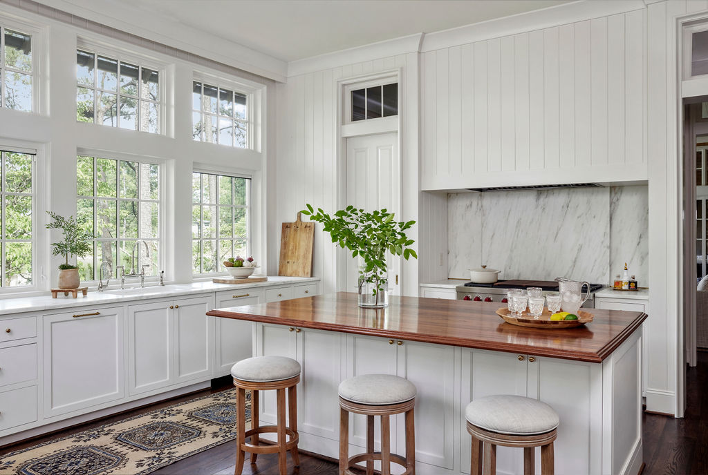 Large windows in white kitchen with walnut wood island | Twin Construction